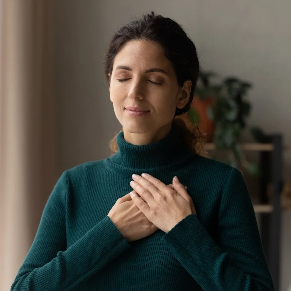 Woman pausing calmly at home, taking a mindful moment during her day